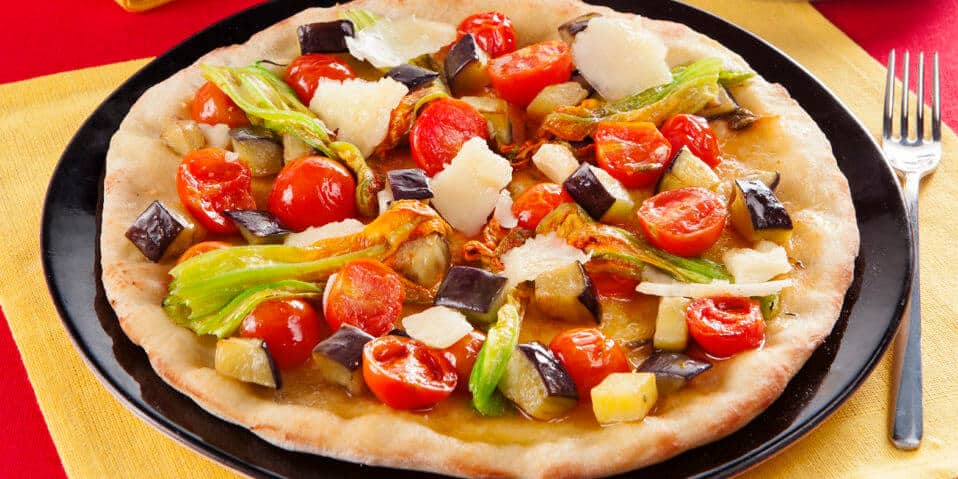 Mediterrane Pizza mit Kirschtomaten, Aubergine, Zucchiniblueten und Parmesan