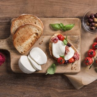 Bruschetta mit Mozzarella, Kirschtomaten, Oliven und Basilikum